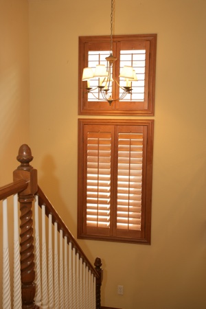 Wooden plantation shutters in tan stairwell.